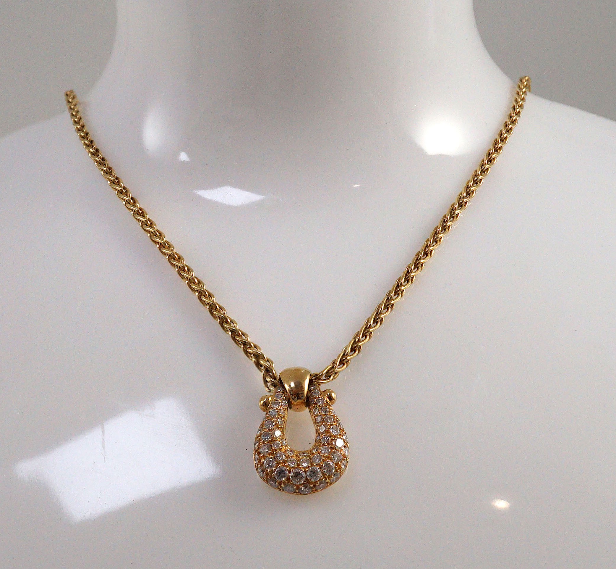 A modern French 18ct gold and pave set diamond 'U' shaped pendant, on a French 18ct gold chain